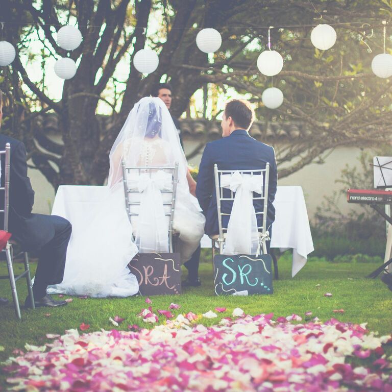 A couple seated together during their outdoor wedding ceremony